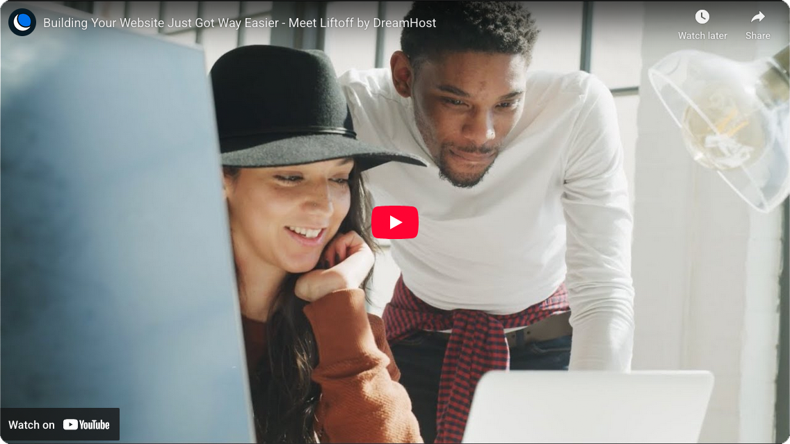 Two people look at a laptop screen together, smiling, in a bright room. The image is from a YouTube video about website building by DreamHost.